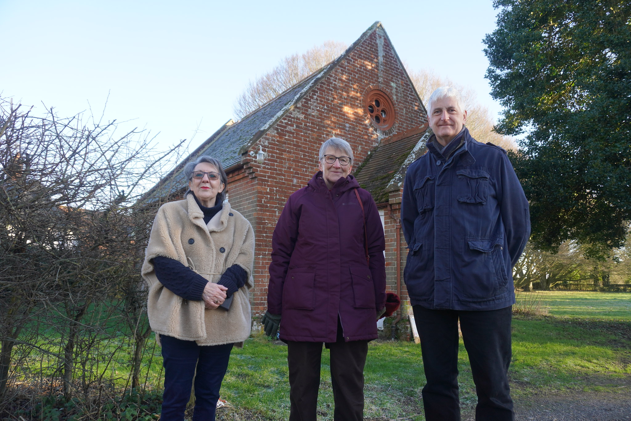 Three Churchwardens standing in front of a parish room on a frosty day.