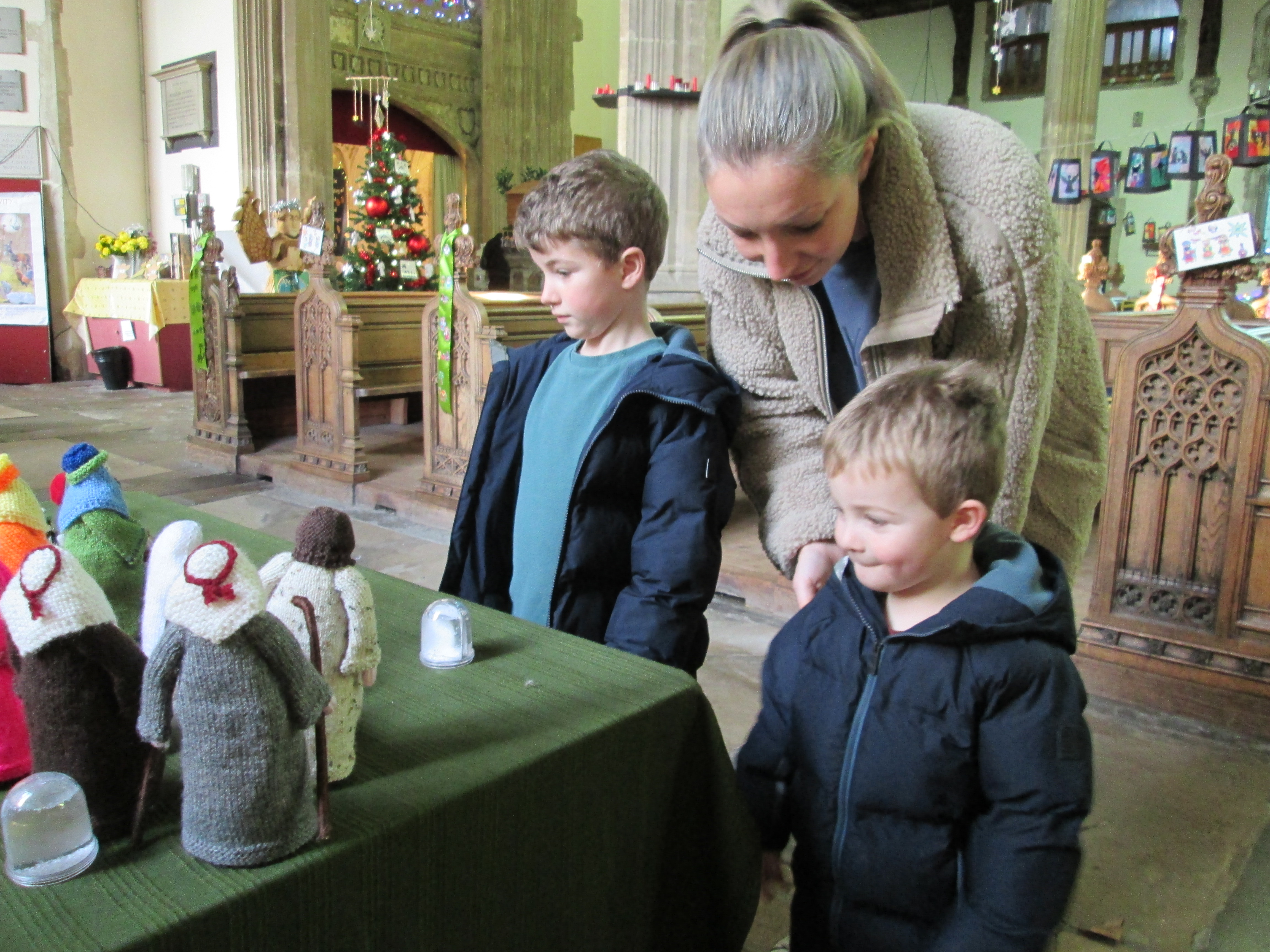 Family group looking at a knitted nativity
